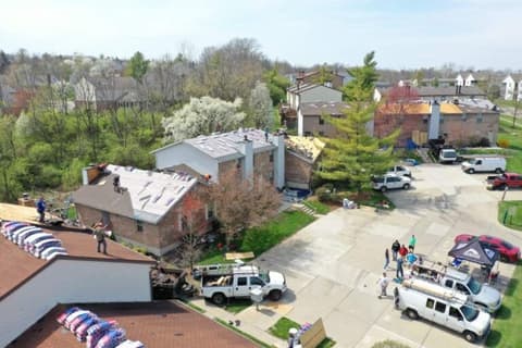 Aerial view of crew and trucks at roofing job